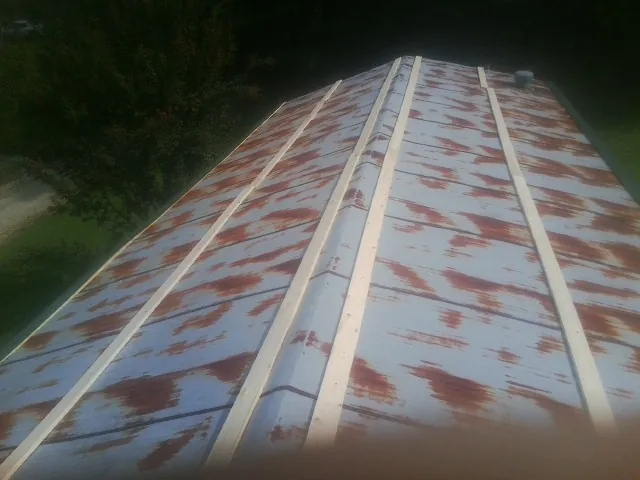 Rusted metal roof panels with new wood purlins before replacement — Storm Damage Roof Repair in Bumpus Mills by Roofing Brothers