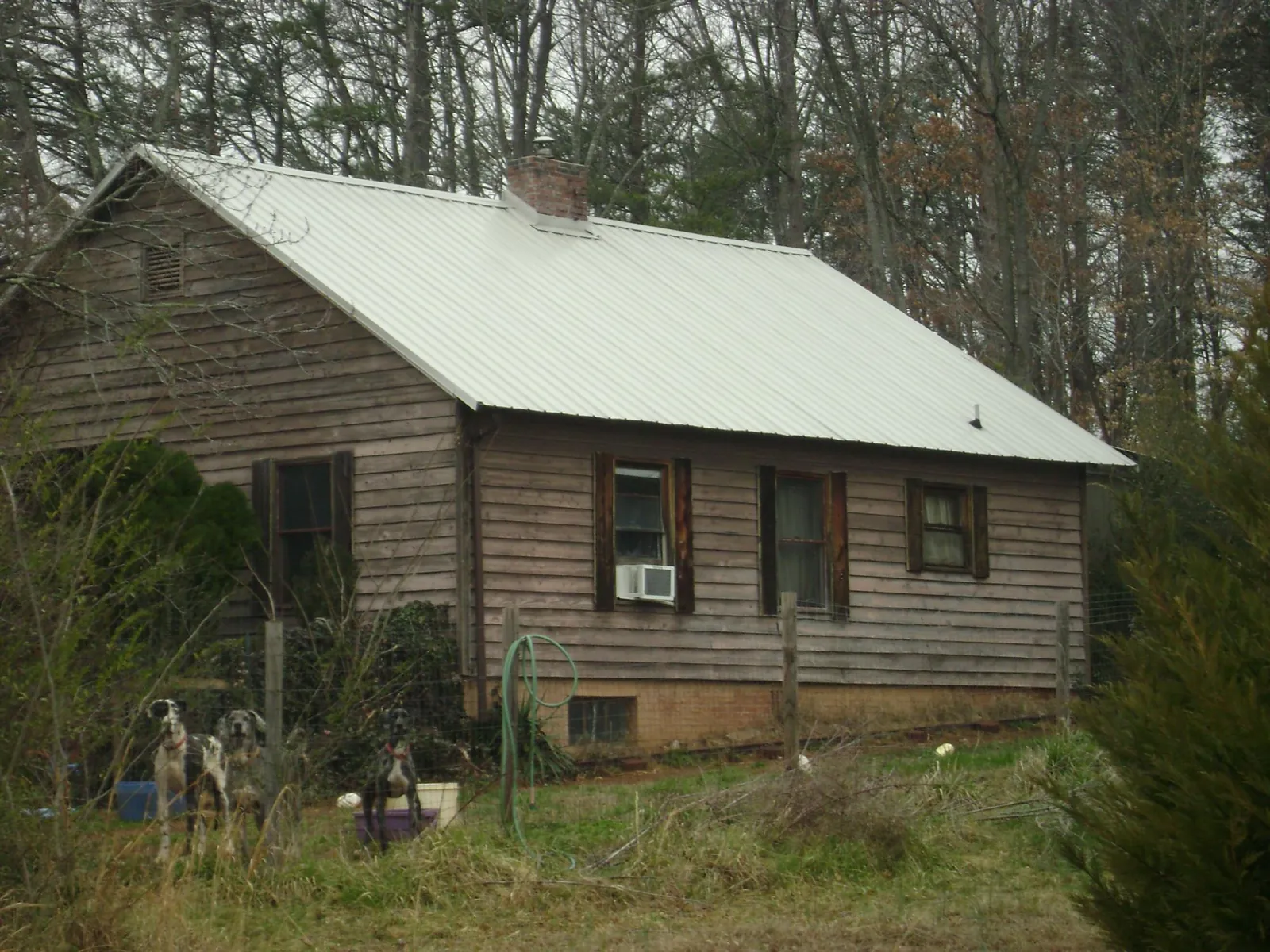 White metal roof on an old wood sided farmhouse, from a Metal Roof Installation job in Bumpus Mills